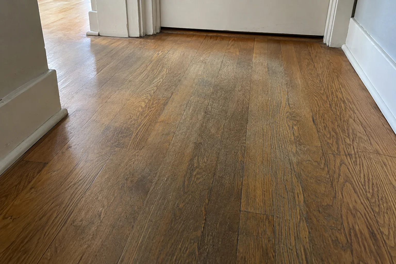 Worn traffic path across an older oak floor